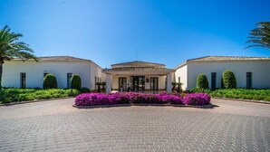 A building with a symmetrical facade, a central entrance, and a paved driveway. - Stunning Penthouse Apartment in Las Colinas - LS18LC (Las Colinas)