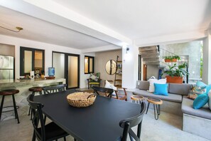 A modern interior with a dining area, kitchen, and living space. - Villa Robalo A - Villas del Palmar (Sayulita)