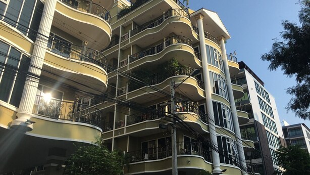 A multi-story building with balconies, large windows, and a central column. - Pratumnak 1 bed Condo With sea View (Pattaya)