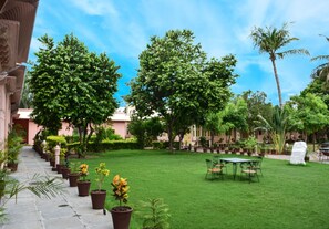 Relax in a serene outdoor space surrounded by lush greenery and a seating area.