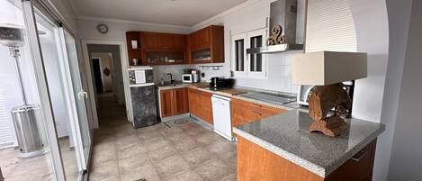 A modern kitchen with wooden cabinets, a granite countertop, and a built-in microwave.