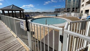 Ein Poolbereich mit einem Schild 'KIDDIE POOL', einer Holzterrasse und einem Pavillon.