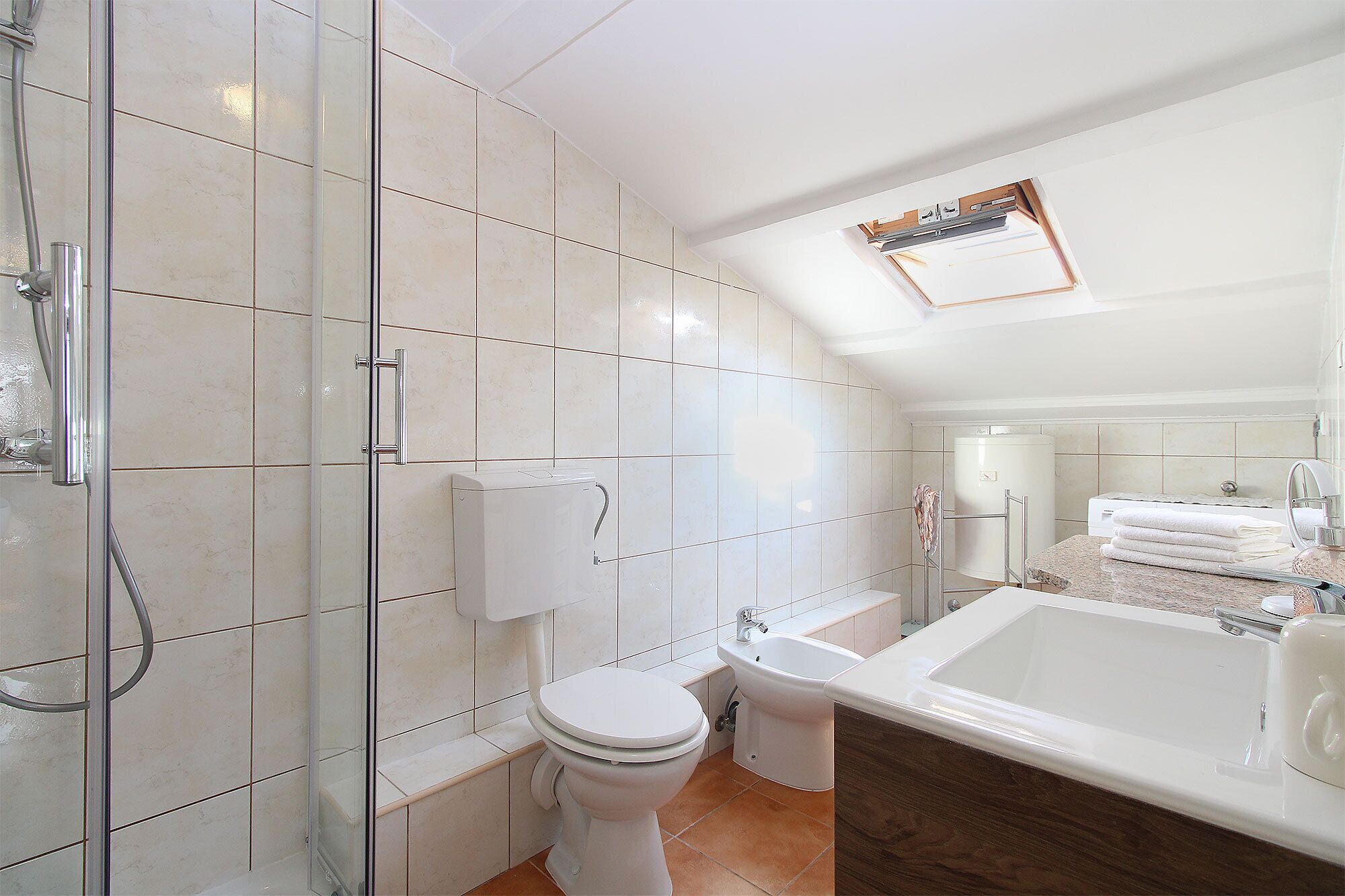 A modern bathroom with a shower, toilet, bidet, and bathtub.