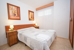 1 dormitori, planxa i posts de planxar i roba de llit 