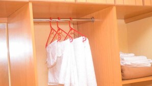 A wooden closet with a hanging rod holding white towels. - Stay.Plus Makey Cozy Homes (Ngong)