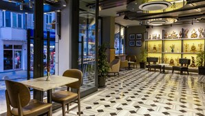 Un interior moderno con piso de cuadros, zona de estar y objetos decorativos en estantes.