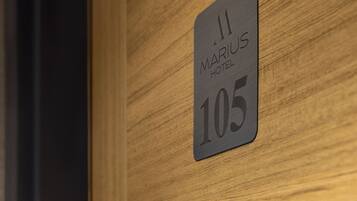 A hotel room number sign with the text "MARIUS HOTEL 105" on a wooden wall.