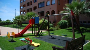 Un parc infantil amb tobogan, cadira de balanç i balancí.