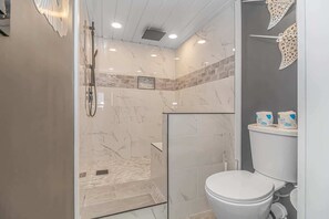 Een bad/douchecombinatie, een haardroger, handdoeken, shampoo