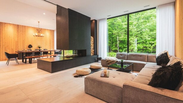 Una sala de estar moderna con un ventanal grande, una chimenea y un comedor.