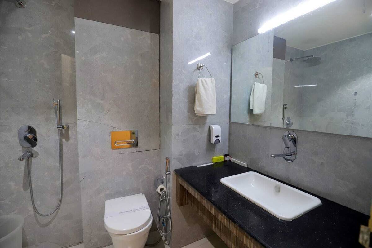 A modern bathroom with a shower, toilet, and sink.