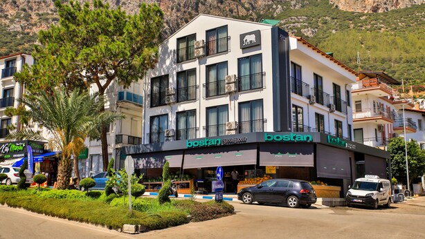 Un edificio de varios pisos con una tienda de frutas y verduras y un restaurante llamado 'boston' en la planta baja.