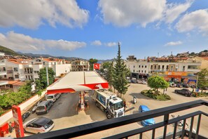 A parking lot with a large truck, several cars, and a gas station. - Joyy Suit & Apart (Kas)