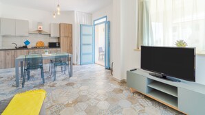 A modern kitchen with a dining area, a TV, and a large window. - Holiday Home "MisMar 2" with Sea View, Garden & Wi-Fi (Noto)
