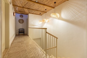 Staircase leads to an upper level, flanked by a bench and railing.