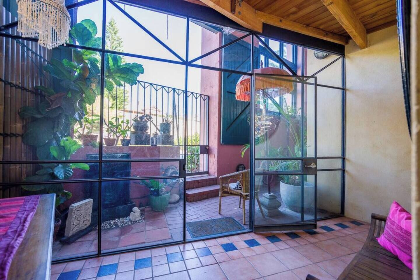 A room with a glass partition, a wooden ceiling, and a tiled floor.