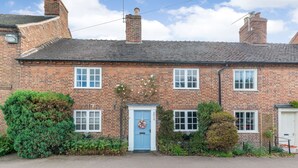 A traditional brick house with a blue door, white windows, and a small garden. - Darwen (Rugeley)
