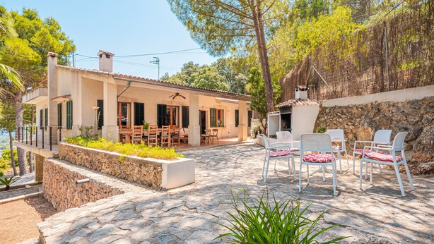 A house with a patio, stone flooring, outdoor furniture, and a view of the surrounding landscape. - Pet-Friendly Villa Ses Basses with Mountain View, Pool & Wi-Fi (mancor de la vall)