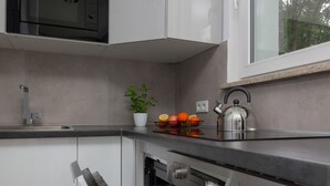 A modern kitchen with stainless steel appliances, a built-in oven, and a kettle on the counter. - Stylish Studio in Mokotow | Balcony | Close to Metro (Warszawa)