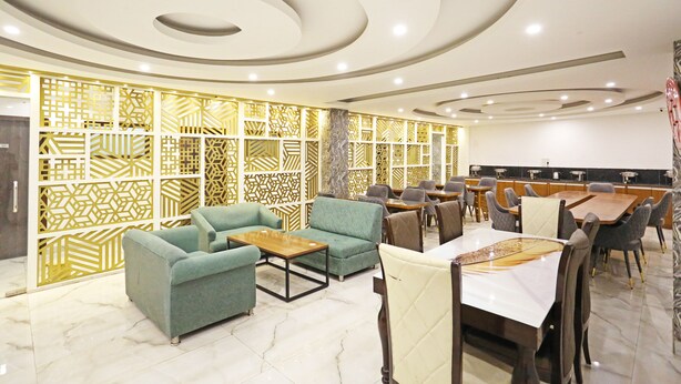 A modern interior with seating arrangements and a dining area. - MyHomeHotels – Hotel Ambrosia (New Delhi)