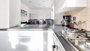 Una cucina moderna con elettrodomestici in acciaio inossidabile, una macchina da caffè e un barattolo di zucchero.
