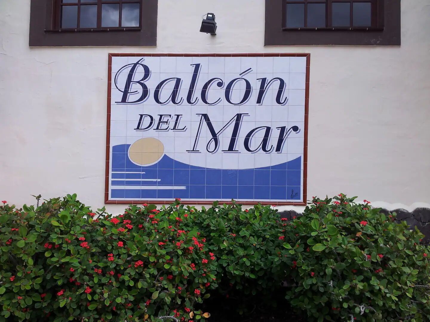 Schild für "Balcon del Mar" mit Wellen- und Sonnendesign.