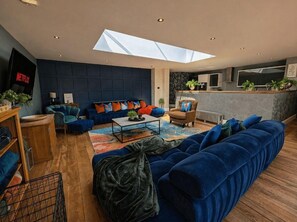 Un salon moderne avec un canapé, une table basse et un téléviseur.