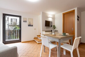 Un espace repas comprenant une table, des chaises, une machine à café et une vue sur l’extérieur.