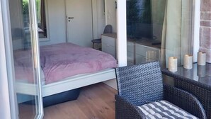 Une chambre à coucher avec un lit, une chaise et un téléviseur.