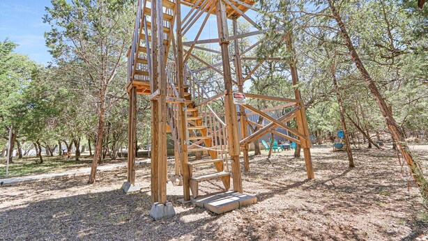 A wooden structure with a staircase and a platform, surrounded by trees. - Come On Inn | Close to Downtown Wimberley! (Wimberley)