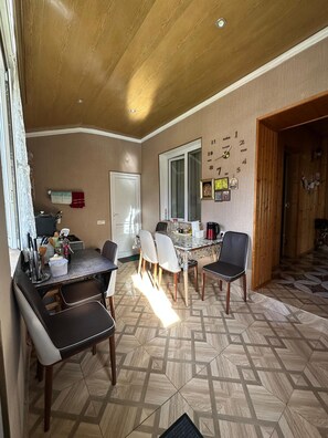 A dining area with a table, chairs, and a clock on the wall.