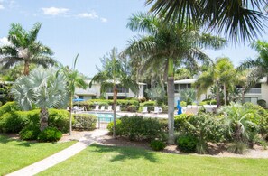 A resort with a pool, palm trees, and a well-maintained garden.