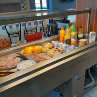 A buffet with various food items and beverages, including fruits, meats, and dairy products.