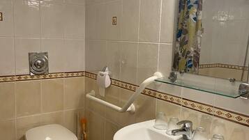Een badkamer met toilet, wastafel en douche.