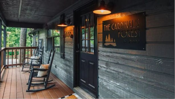 Un porche de madera con mecedoras y un cartel que dice "The Cardinal's Forest".