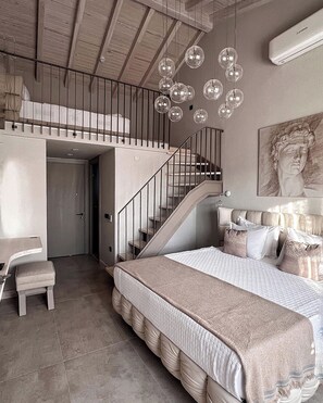 Un dormitorio con una cama grande, una escalera y un colgador de luz.