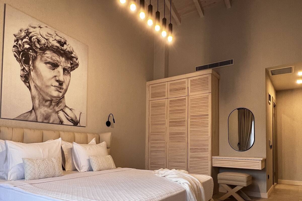 Makuuhuoneessa on suuri sänky, vaatekaappi, peili ja kattovalaisin.