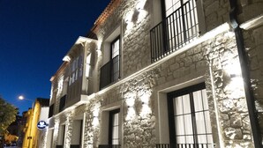A stone building with multiple windows and balconies, illuminated by artificial lighting. - Ala Da Vinci Hotel Alaçatı (Cesme)