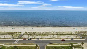 A beach with a road and beachgoers. - Sleeps 10, Pet Friendly, Fully Fenced Back Yard! (Mexico Beach)