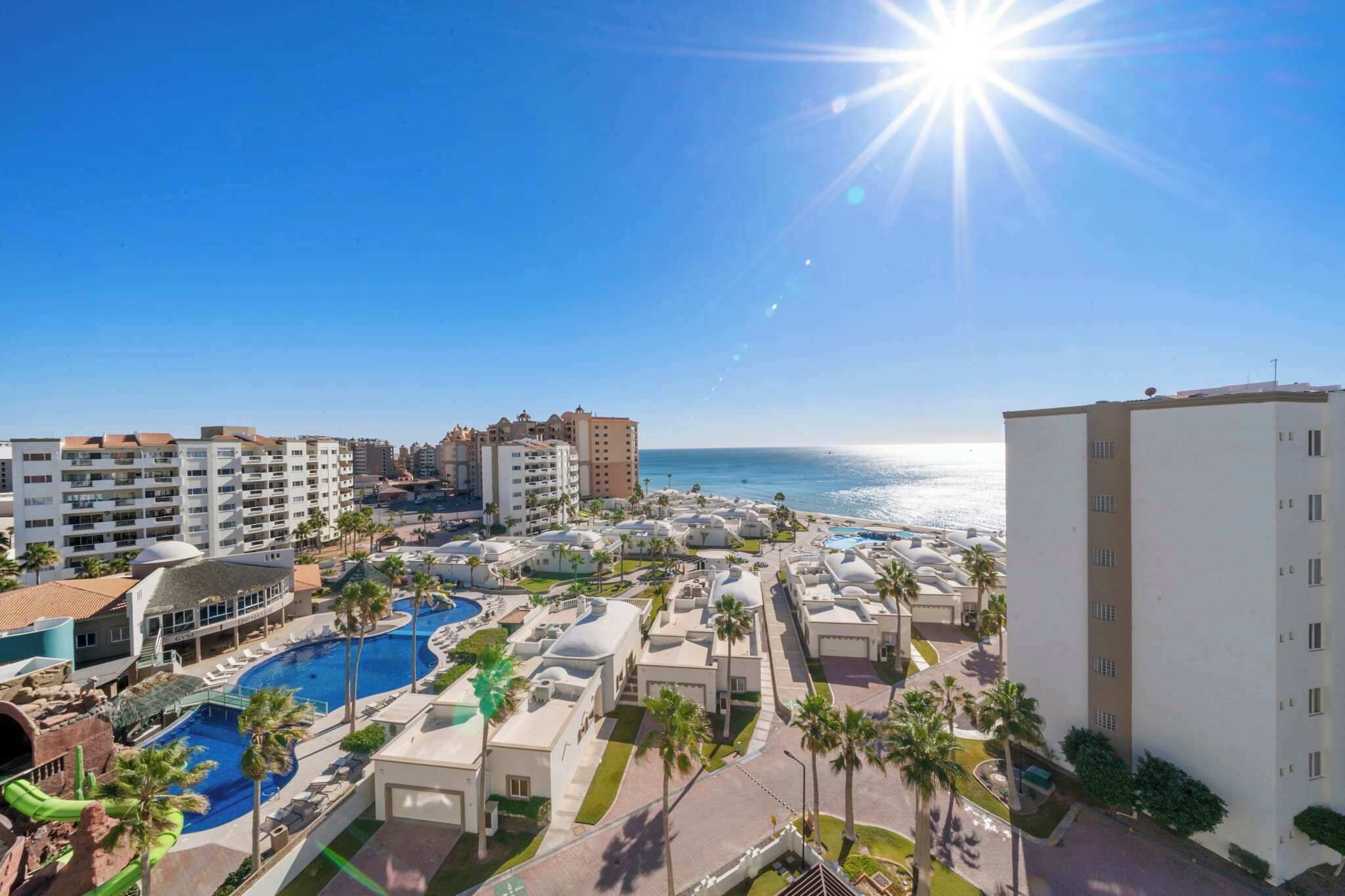 Een resort met meerdere gebouwen, een zwembad en uitzicht op de oceaan.