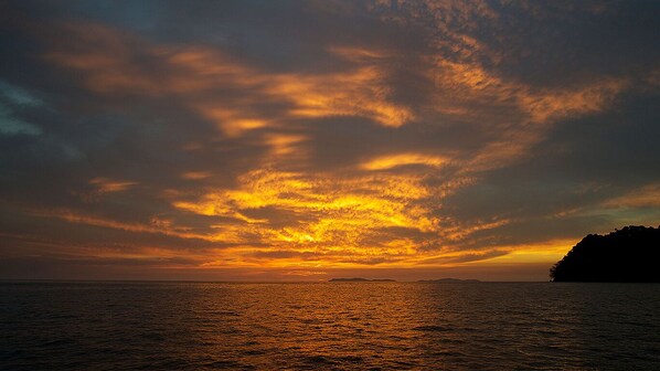 A sunset over a body of water with a distant landmass. - VIP amazing private island (Veraguas)