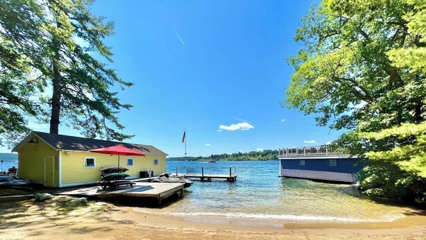 Una proprietà sul lago con un molo, un piccolo edificio giallo e una struttura blu.