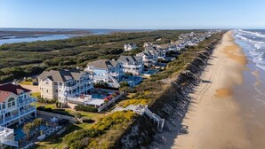 Una zona residenziale sulla costa, con case affacciate sulla spiaggia, tra cui abitazioni con balconi e piscina.