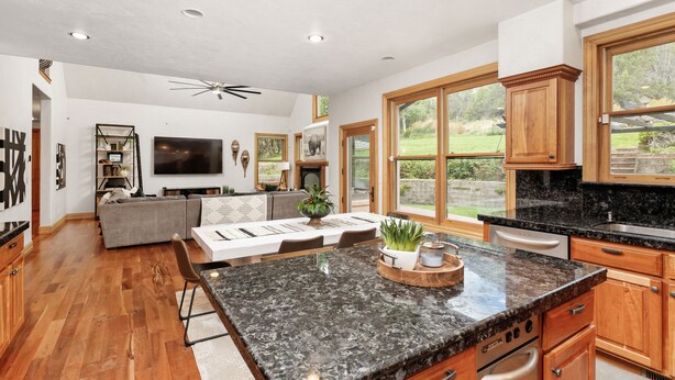 A spacious kitchen with granite countertops, wooden cabinets, and a large island. - Warm Chalet in the beautiful Rocky Mountains (Carbondale)