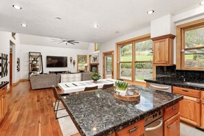 A spacious kitchen with granite countertops, wooden cabinets, and a large island. - Warm Chalet in the beautiful Rocky Mountains (Carbondale)