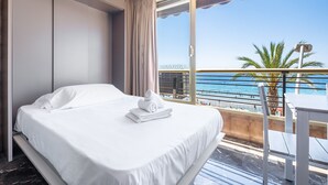 A hotel room with a bed, a view of the sea, and a balcony with a table and chairs. - Benipark 4-2-B Poniente Beach (Benidorm)