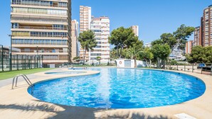 A swimming pool surrounded by tall residential buildings, with a clear sky above. - Benipark 4-2-B Poniente Beach (Benidorm)
