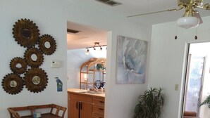 Un soggiorno con un tavolo in vetro, un mobile in legno e una ventola a soffitto.