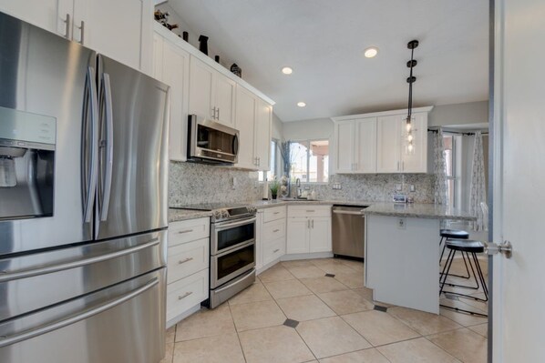 Enjoy cooking in this well-equipped kitchen with a refrigerator, microwave, and oven, plus a convenient island with bar stools.