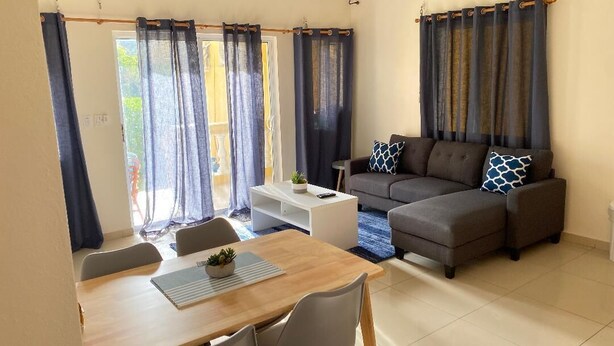 Ein Wohnzimmer mit einer Couch, einem Esstisch und einem Couchtisch.